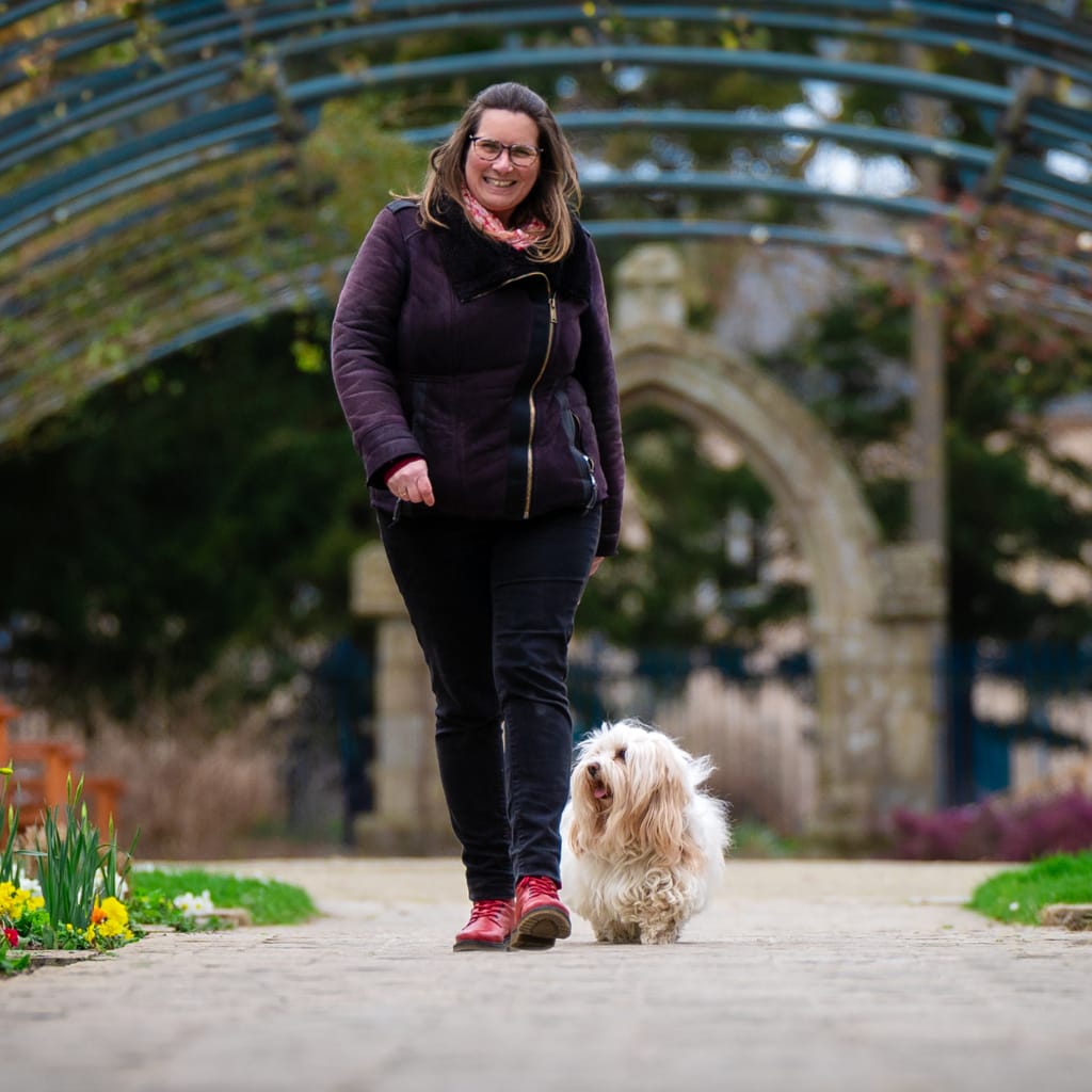 Sonia et Zitou marchant sous l'arche de la roseraie du Jardin des Plantes à Saint-Nazaire en Loire-Atlantique - Chien Reporter