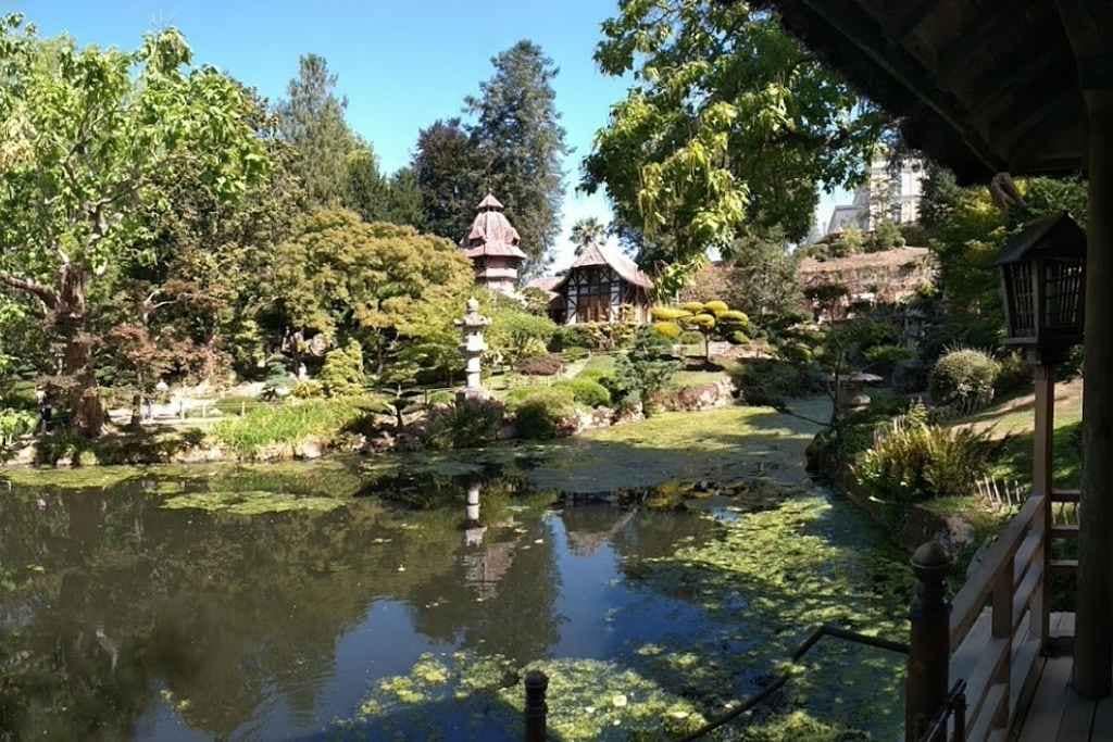 Escapades au-delà de la Loire-Atlantique : vue d'un étang et des pavillons en bois dans l'un des paysages époustouflants du parc orientale de Maulévrier lors d'une visite de vacances avec mon chien dans le Maine et Loire