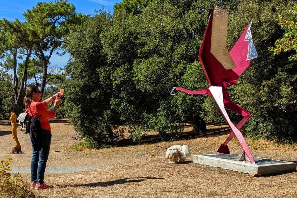 Parcs et Jardins avec son chien : une dogmom et son chien prenant en photo une scupture d'oiseau au parc du pointeau