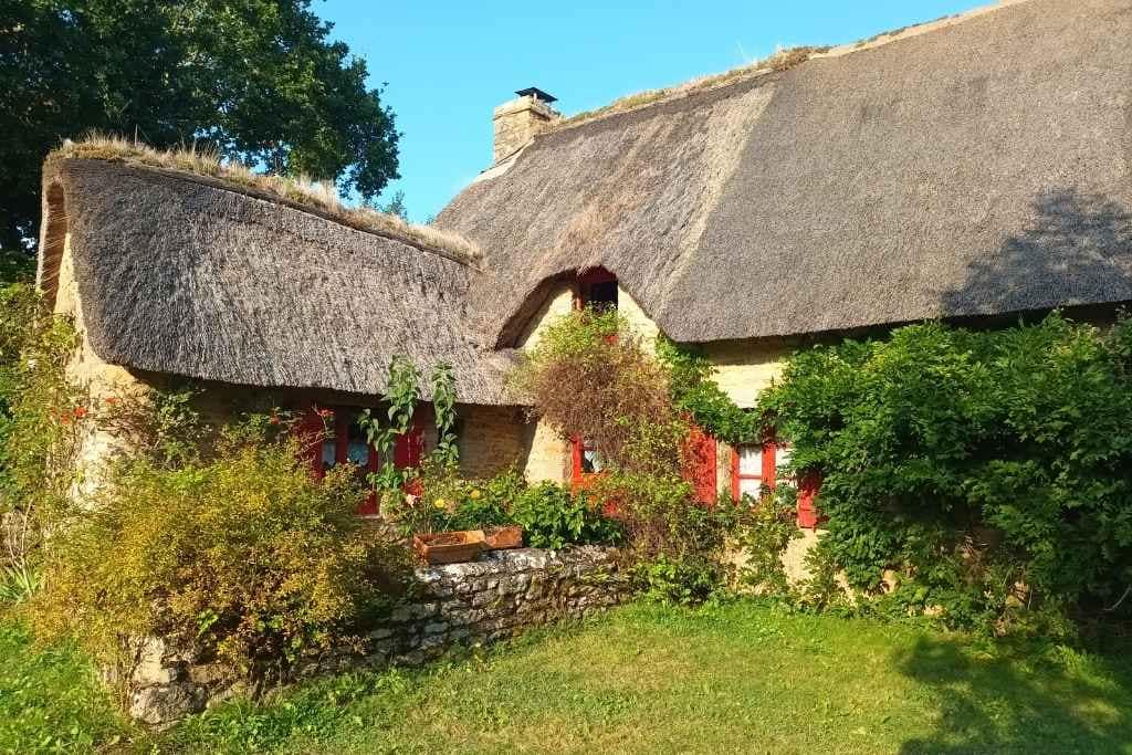 Patrimoine & Sites Culturels avec son chien : chaumière au toit de chaume et au volet rouge dans le village de kerhinet à Saint-Lyphard