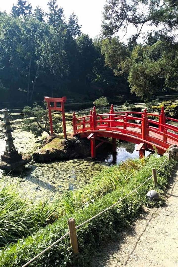 Le célèbre pont rouge dans son cadre verdoyaant au dessus du lac du parc oriental de Maulévrier lors de ses vacances dans le Maine et Loire